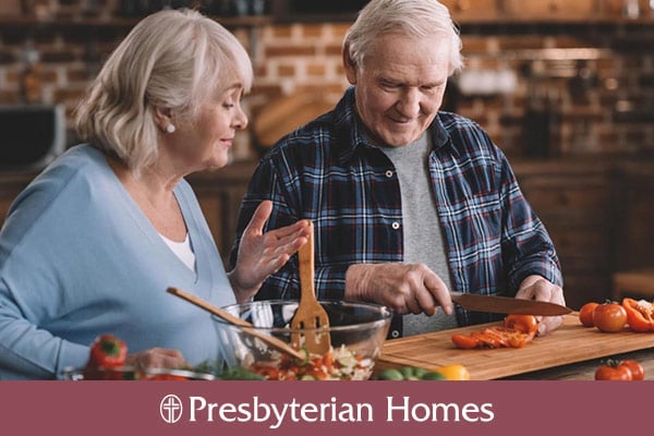 two older adults cooking a healthy meal together